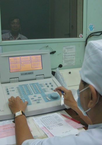 Điếc do… suy thoái kinh tế - 1 Bác sĩ đang đo thính lực cho bệnh nhân