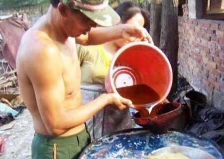 Kinh hoàng “công nghệ” tái sản xuất dầu ăn - 2 Một công nhân đang pha chế dầu tại lò tái chế dầu ăn