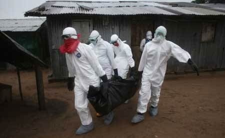 Tây Phi rúng động vì hàng chục bệnh nhân Ebola biến mất - 2 Các nhân viên y tế đang di dời một xác người thiệt mạng vì virus Ebola ở Liberia. Ảnh: Getty Images