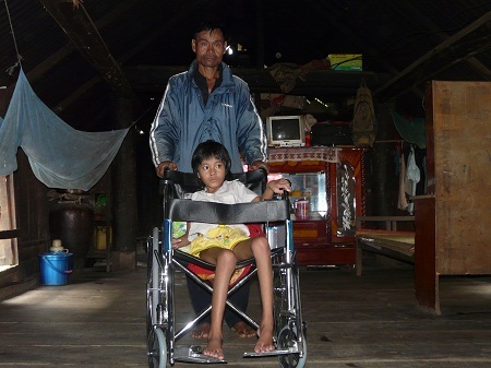 Cháu H'Phôn trên chiếc xe lăn.