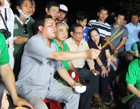 Cậu Thủy - mặc áo xám, đang cầm hương làm lễ áp vong nhập hồn.