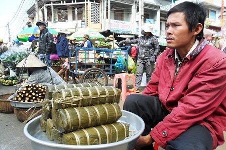 Một người đàn ông bày bán bánh tét trong phiên chợ cuối năm ở thành phố Buôn Ma Thuột.