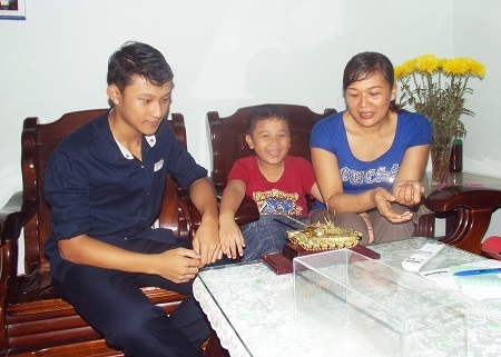 Ngồi bên cạnh mẹ, Minh Sơn tỏ ra rất khoái chí với món quà xe tăng của bố.