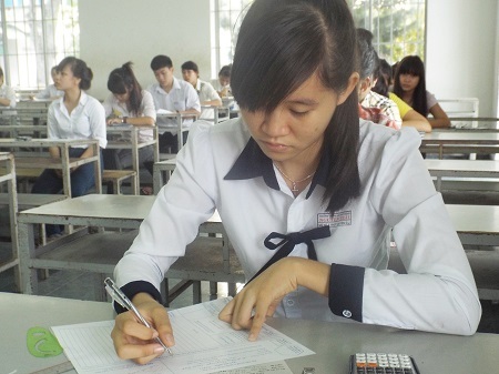 Thí sinh ĐH Nha Trang ghi thông tin cá nhân vào bài thi và giấy nháp, sáng 9/7. (Ảnh: Viết Hảo)