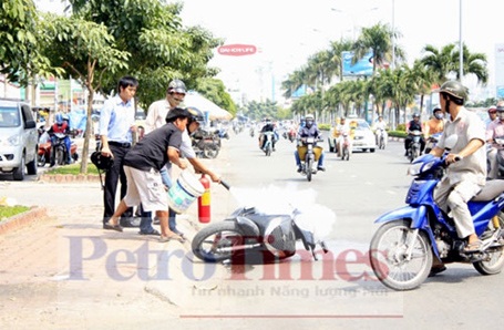 Xe SH đang chạy bỗng dưng bốc cháy - 1 Người dân dùng bình cứu hỏa của tòa nhà gần đó để dập tắt ngọn lửa trên xe