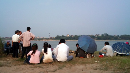 Hà Nội: Chụp ảnh ở bãi đá sông Hồng, 1 sinh viên tử vong - 1 Bạn bè nạn nhân ngóng chờ lực lượng chức năng đưa thi thể nạn nhân lên bờ.