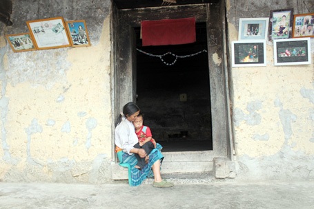 Chị Ly Thị Chúa ôm con bên bậu cửa, hình ảnh quen thuộc của phụ nữ người Mông