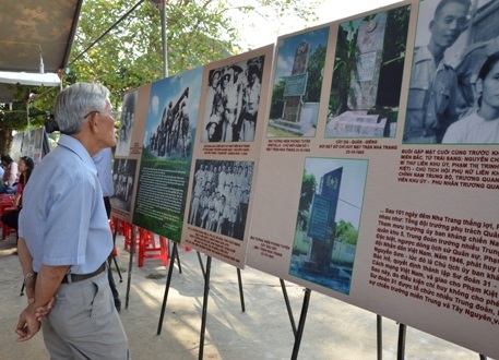 “Danh tướng Phạm Kiệt - bản lĩnh và tài đức” - 3 Cán bộ lão thành chăm chú xem lại các bức ảnh và gợi nhớ về ký ức thời chiến tranh.