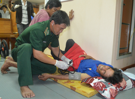 Cấp cứu ngư dân Phạm Minh Hòa ngay trên tàu cứu hộ cứu nạn trước khi chuyển vào bệnh viện.