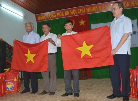 Chủ tịch Ủy ban TƯ MTTQVN (bìa phải) trao cờ Tổ quốc cho Nghiệp đoàn nghề cá ở Lý Sơn.