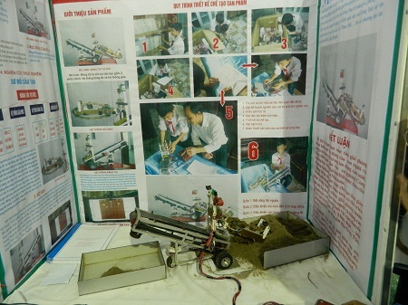 Cậu bé Hoan giới thiệu cho khách tham quan về công dụng của Băng tải tự xúc