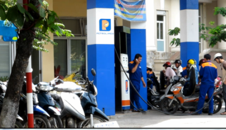 Nhân viên cây xăng cũng nghe điện thoại (Ảnh: Đại Dương)