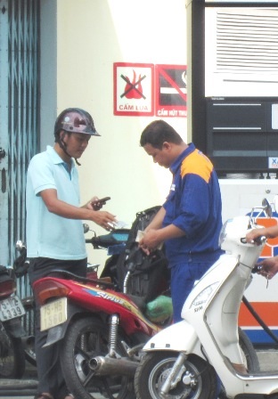 Khách dùng điện thoại tại cây xăng nhưng không bị ai nhắc nhở (Ảnh: Đại Dương)