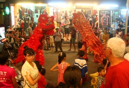 Lân múa kiểu chầu trước cửa hàng bán đồ lưu niệm ở phố Tây đường Phạm Ngũ Lão