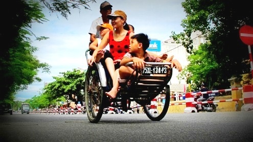 1 cặp đôi người Tây tỏ vẻ thích thú trên phương tiện xích lô thô sơ