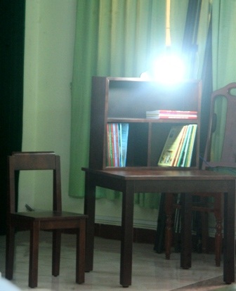 Góc học tập gồm một bàn gỗ, một kệ để sách gỗ liền với bàn, 1 ghế gỗ và 1 cây đèn học.