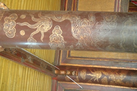 Cột chống trong lầu Ngũ Phụng sơn đỏ với rồng thếp vàng đã bị phai màu qua thời gian