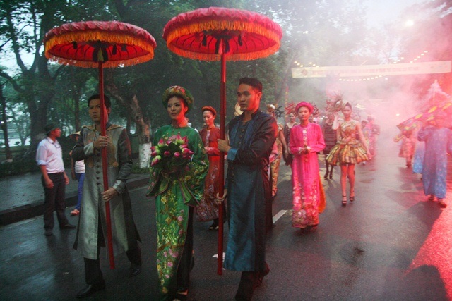 Ngắm “hoàng hậu” Ngọc Hân trong lễ rước tôn vinh nghề Việt - 5 Dù trời mưa, nhưng hoàng hậu Ngọc Hân vẫn bước dáng đẹp, tươi cười trên đường phố cổ ở Huế