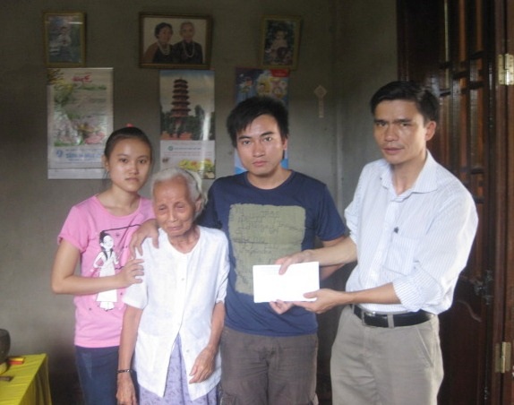 Trao quà tới học sinh mồ côi có hoàn cảnh đặc biệt khó khăn - 1 Em Vân (ngoài cùng bên trái) cùng bà ngoại già, anh trai nhận quà từ Hội Chữ thập đỏ.