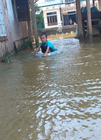 Bỏ chậu vào giữa phao làm thuyền thúng bơi trên dòng nước ngập