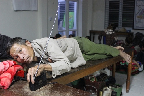 Chăm chú lắng nghe tin bão qua radio mang theo lúc sơ tán.