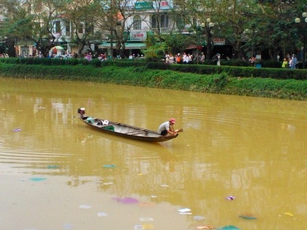 Thợ lặn thắp hương trên ghe và thả vàng mã để cúng nơi khoảng sông tìm thấy em My