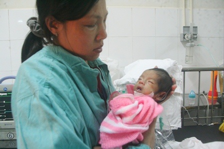 Thăm những bệnh nhân nhi ở lại BV đêm Giao thừa - 5 Một cháu nhỏ bị bệnh nặng người nhỏ và rất ốm trong vòng tay mẹ