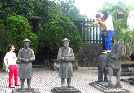 Du khách thích thú cưỡi ngựa đá lăng vua lấy hên năm mới - 13 2 du khách nữ đứng hẳn lên lưng ngựa đá cười thích thú