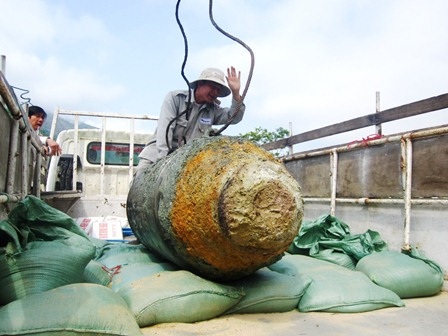 Thót tim xem quá trình di dời, hủy nổ bom “khủng” - 8 Dùng dây cẩu đưa bom lên thùng xe.