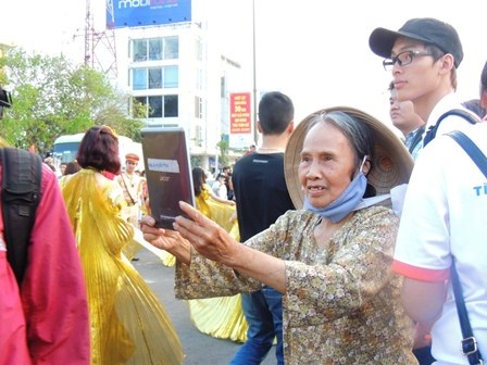 Bà Vi dùng Ipad chụp lại hình ảnh nghệ sĩ trong quảng diễn đường phố