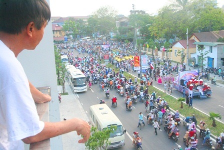 Một người dân thích thú xem lễ hội từ nhà cao tầng