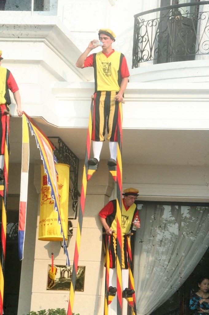 Tranh thủ dựa lưng vào khách sạn để uống nước