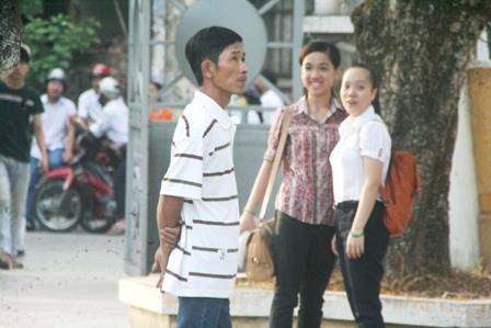 Cha mẹ sát bước bên con trong kỳ thi trọng đại - 3 Một ông bố đứng dưới sân trường ngoài nhìn lên phòng thi của con ở tầng 2
