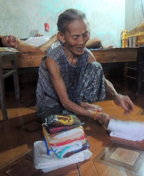 Bố mẹ già 80 oằn lưng chăm sóc con trai 51 tuổi liệt giường - 4 Bà Túc sắp lại đống tả của con trai 51 tuổi mà òa khóc