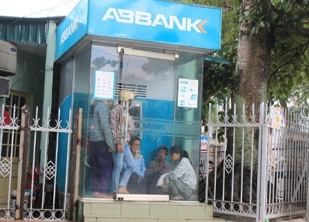 Phụ huynh ướt sũng đứng chờ con trong mưa - 7 Ngồi cả trong cây ATM