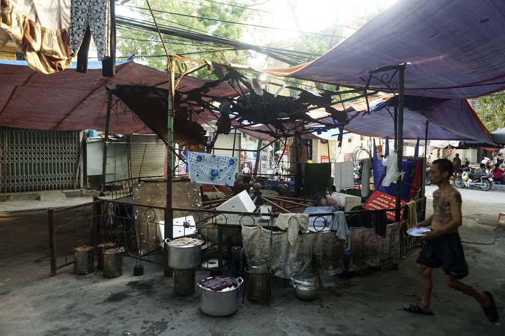 Những đứa trẻ chơi đùa bên cạnh những bàn nhậu ồn ào.