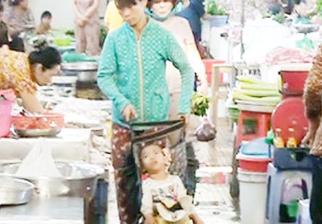 Mang trẻ bại não đi ăn xin - 1 Bà Phúc đẩy xe đưa cháu bé đi ăn xin trong chợ. Ảnh: DĐ