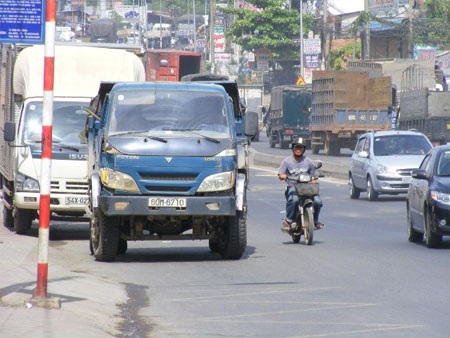 Xe tải lật nghiêng sau khi “bay” qua dải phân cách - 1 Chiếc xe tải (mầu xanh) sau khi đã được xe cẩu giải cứu