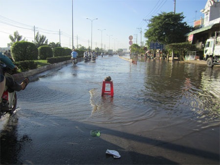 Người khốn khổ, kẻ “hốt bạc” nhờ triều cường - 1 Chiếc ghế nhựa được đặt ra giữa đường sau khi đã có hàng chục xe máy bị sa hố