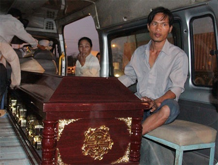 Anh Bình ngồi bên quan tài vợ