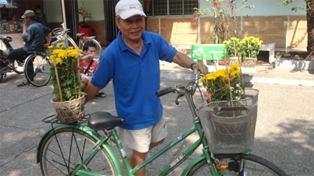 Một cụ ông vui vẻ vì chọn được những chậu hoa ưng ý, giá rẻ.