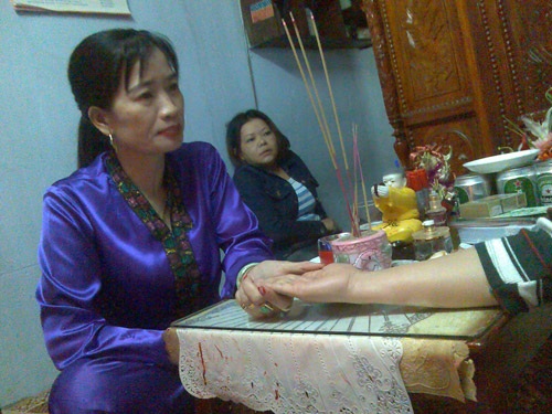 Xếp hàng chờ... giải hạn - 2 Một “cô” ở Đà Nẵng đang xem bói cho khách. Ảnh: Hoàng Dũng