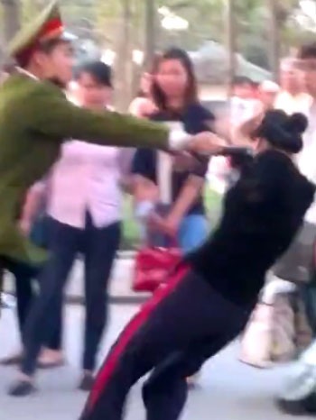 Chuyển công tác Công an phường đẩy ngã cô gái - 2 Một cô gái - bạn của người vi phạm vào can ngăn đã bị vị công an này đẩy ngã xuống đường.