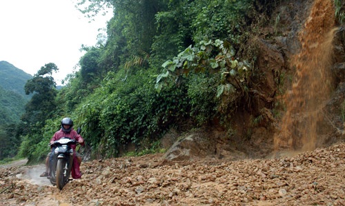 Người dân địa phương vượt qua khu vực sạt lở do trận mưa gây ra...