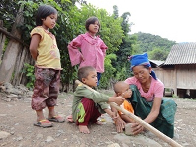 Niềm vui cho những mối tình Việt - Lào “vắt vẻo” đường biên - 1 Một trong những cô dâu Lào đầu tiên tại Mường Típ bên con cháu (Ảnh: Vietnam+)