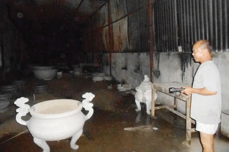 Ông Tùng chỉ cho xem khu xưởng máy trước kia, bây giờ được ông mượn để làm chậu cây cảnh.