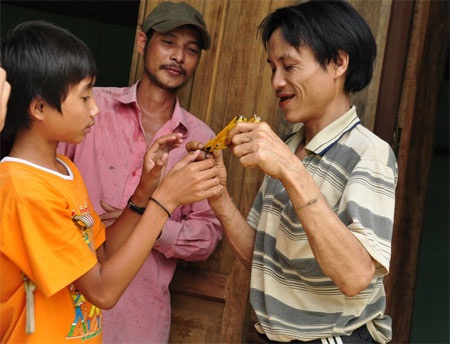 Anh Loan đã dần quen với cuộc sống cộng động, anh đang chơi bắn ná thun với cháu.