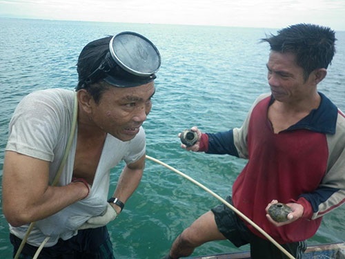 Một thợ lặn đưa cổ vật lên tàu