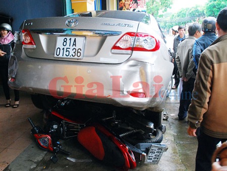Tài xế ngủ quên sau khi gây tai nạn - 1 Xe mô tô bị cuốn vào gầm xe ô tô. Ảnh: Nguyễn Giác