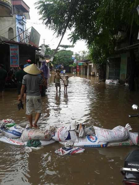 Đắp bao tải cát chặn nước trên đường Tả Thanh Oai (Ảnh: Bùi Then)